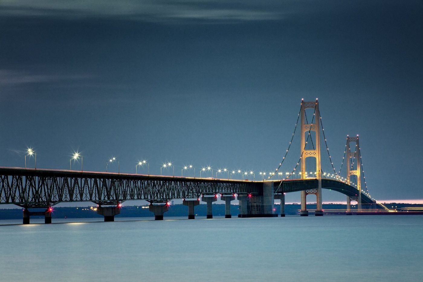 The Mackinac Bridge lit up at night over the Straits of Mackinac